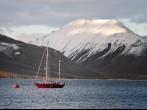 Polish red sailing boat to the buoy in Adventfjorden, in front of Longyearbyen port, snowy mountain background, horizontal